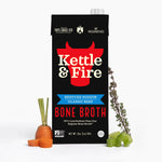 Kettle & Fire reduced sodium beef bone broth carton with carrot and herbs displayed beside it.